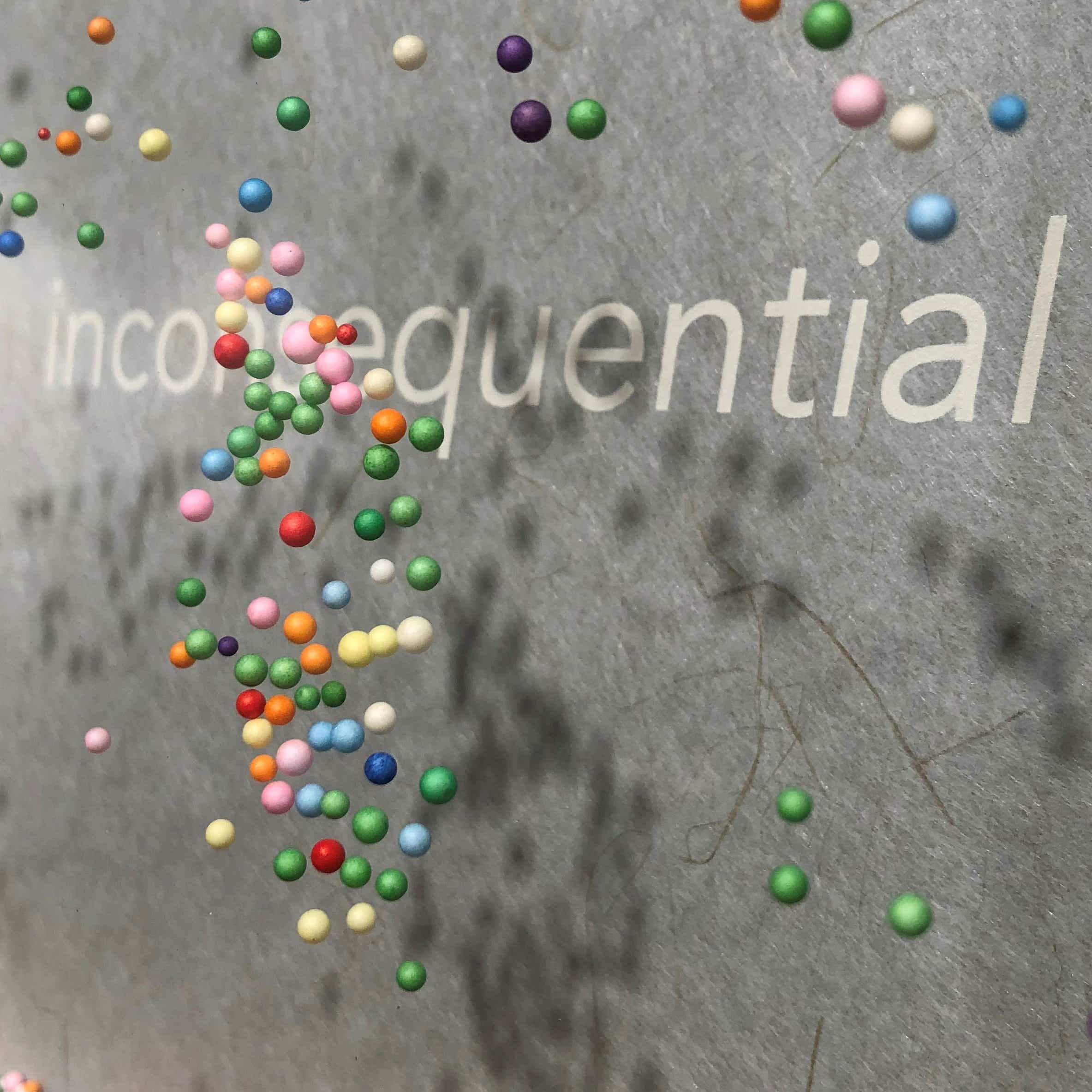 Art by Heather Leier. Multicoloured dots float over a gray background. The word inconsequential is shown amongst the dots.